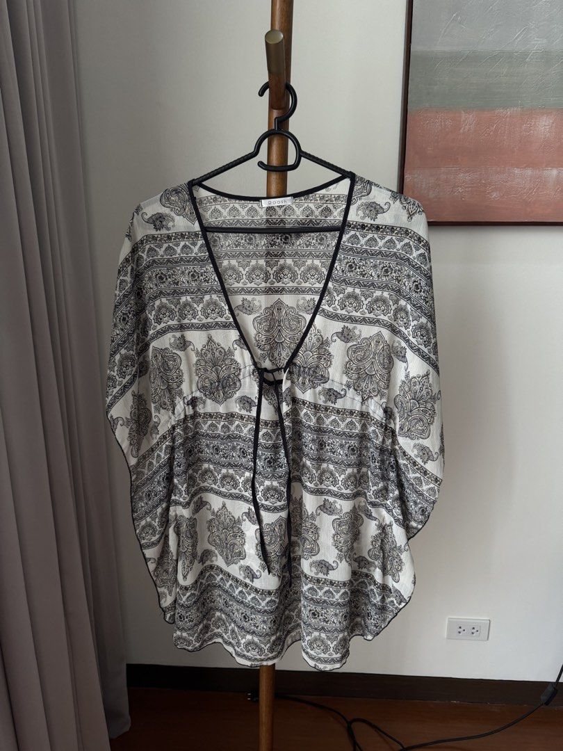 Black and White Patterned Kimono Blouse (Category: Blouses) located in Pasig City. Submitted by kutleyn (Listing ID 1465671295, Image 1). Description: - Brand: Qoosh - Design: Black and white paisley and geometric print all over - Details: V-neckline with black contrast trim and front tie strings - Sleeves: Short flutter sleeves - Fabric: Lightweight and breezy, ideal for warm weather - Style: Versatile casual top or stylish cover-up - Condition: