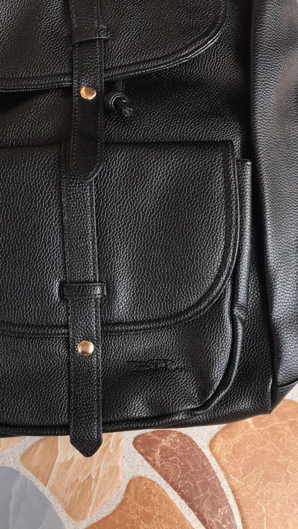 Black Faux Leather Convertible Backpack Shoulder Bag (Category: Backpacks) located in Quezon City. Submitted by davidmelvin28 (Listing ID 1465590563, Image 3). Description: - Color: Black with chic gold-tone hardware - Material: Premium faux leather with a stylish grained texture - Condition: Brand new with tag still attached - Closure: Flap with snap button and secure drawstring top - Storage: Convenient front pocket for easy access - Versatile: