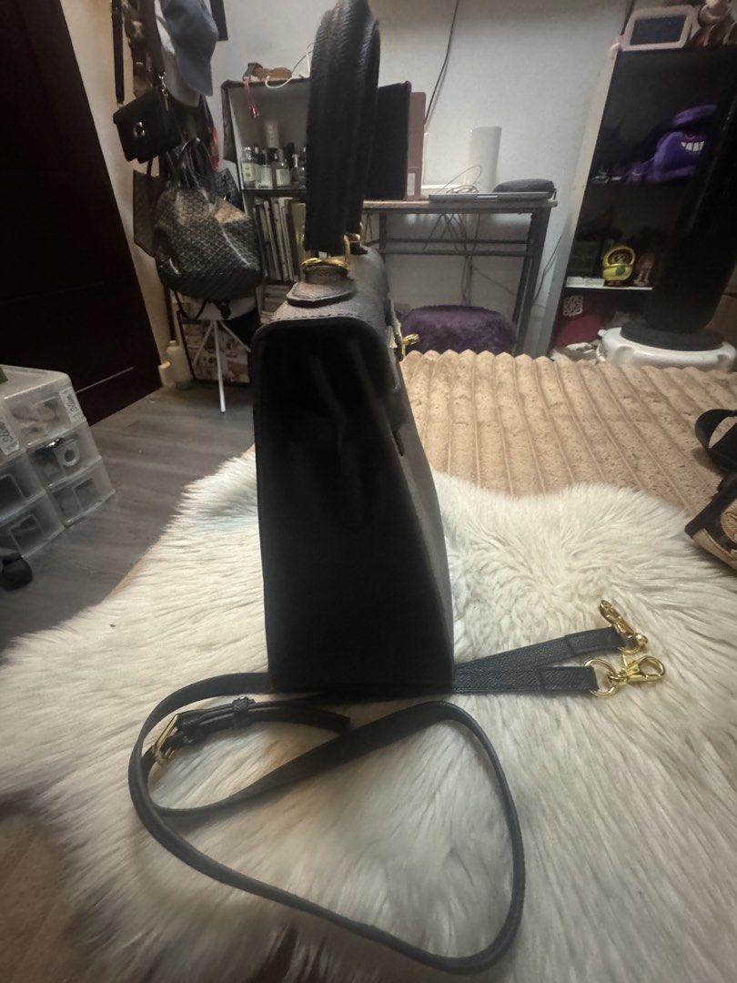 Black structured handbag with gold hardware and shoulder strap (Category: Luxury Bags & Wallets) located in Cavite. Submitted by amaxxingfinds (Listing ID 1465628791, Image 2). Description: Birkin tote bag Kelly Style Color Black Location Bacoor Rfs: Declutter Size 29 CM Width 21 CM Height .