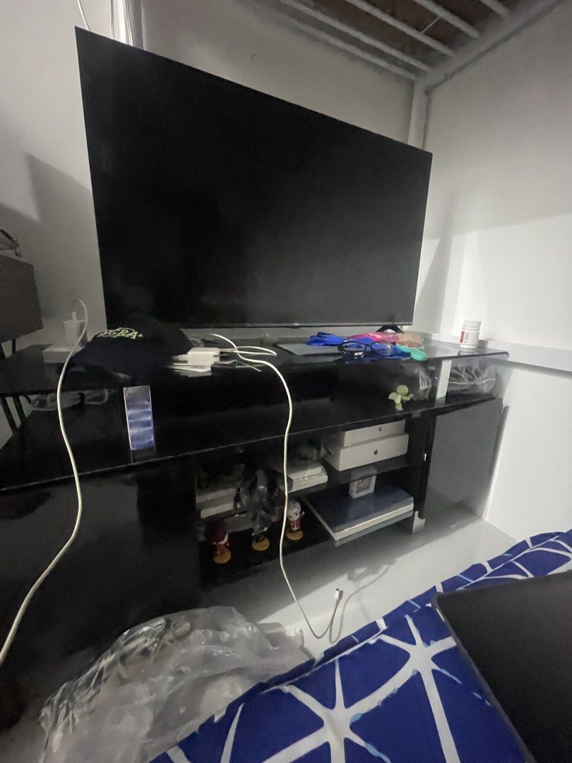 Black TV Console with Flat Screen Television (Category: TV Consoles) located in Teresa. Submitted by tinycloset_ (Listing ID 1465703381, Image 1). Description: Black Glass top 1.2m x 50cm Pick up: Tatalon QC - Sleek glossy black finish that fits any living room or bedroom - Features lower shelves for storing media gear, boxes, and decor - Solid and sturdy structure designed to hold large flat screen TVs - Great space-saving entertainment unit for