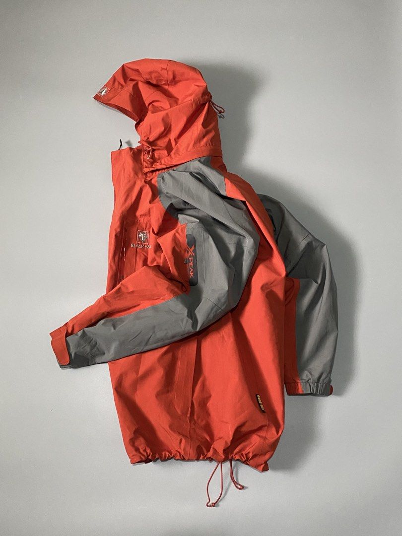 BLACKYAK GORE-TEX JACKET (Category: Coats, Jackets and Outerwear) located in Cebu City. Submitted by dfindss. (Listing ID 1465625714, Image 3). Description: This aesthetic shopping image shows a Black Yak orange and gray waterproof shell jacket. • Design: Features an orange body with contrasting gray shoulders and sleeves, a hood with drawstrings, and the characteristic Black Yak logo on the chest. • Material: Built with waterproof performance fa