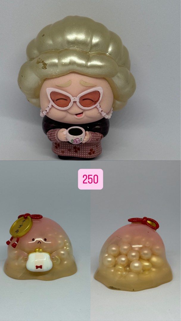 Blind Box Designer Toys Figures (Category: Designer & Blind Box Toys) located in Manila. Submitted by silverfalcon_dbc769 (Listing ID 1465750677, Image 1). Description: - Set of 2 cute designer art toy figures - Figure 1: Elderly lady wearing big pink sunglasses and a patterned cardigan, enjoying a cup of coffee - Figure 2: Translucent pink jelly creature holding a white purse with a gold coin accent, filled with trapped pearls - Perfect fun disp