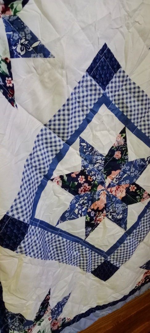 Blue and White Patchwork Quilt with Star Pattern Long Pillowcase (Category: Bedding & Towels) located in Mangaldan. Submitted by closetqwin (Listing ID 1465648168, Image 3). Description: Vintage Pillowcase never been used -Size 29.5 inches Length and 22.5 inches Width - Features a striking central star pattern with checkered borders and floral corner stars - Soft quilted texture with a solid light blue backing and border trim.