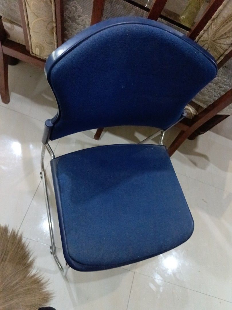Blue cushioned office chair with metal frame (Category: Office Furniture & Fixtures) located in San Juan City. Submitted by pinkdenxel (Listing ID 1465704276, Image 1). Description: - Color: Deep blue with a sturdy metal tubular frame - Comfort: Cushioned seat and backrest for good support - Design: Stackable to save space when not in use - Ideal For: Study rooms, home offices, or extra guest seating - Condition: Good, with minor dust marks from 