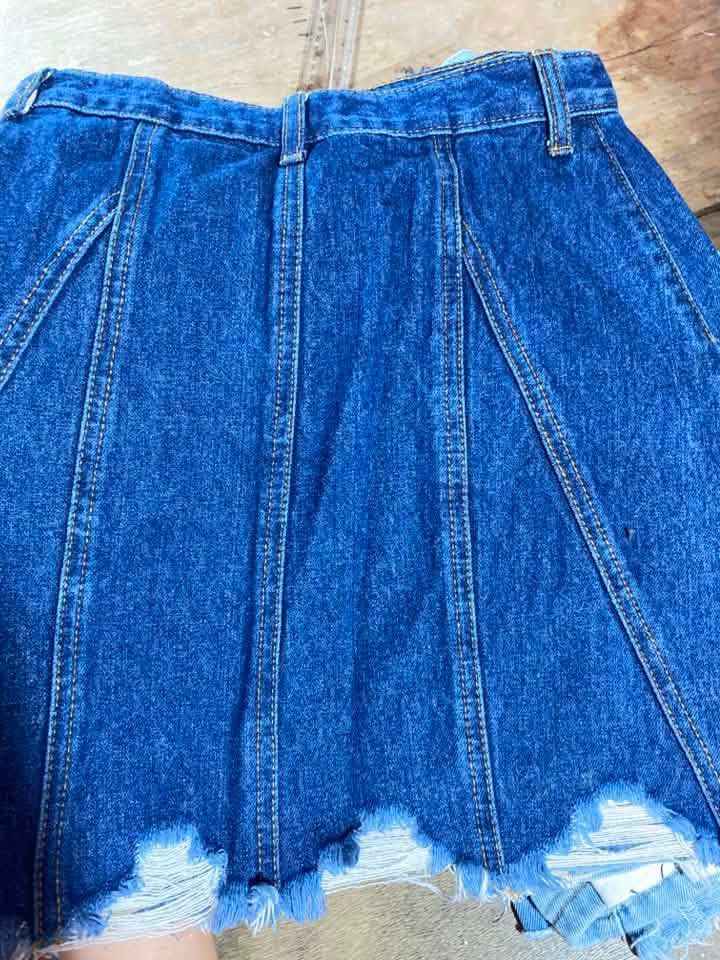 Blue Denim Skirt Distressed Hem Size 24 (Category: Skirts) located in Manila. Submitted by lucky_jinky (Listing ID 1465631396, Image 2). Description: W:24-25 L:14 - Style: Classic skater silhouette with structured vertical panels - Fit: High-waisted with button closure and belt loops - Details: Distressed raw hem and dark wash denim - Label Size: A5 (Waist: 24-25 inches, Length: 19 inches) - Condition: Excellent, ready to wear.