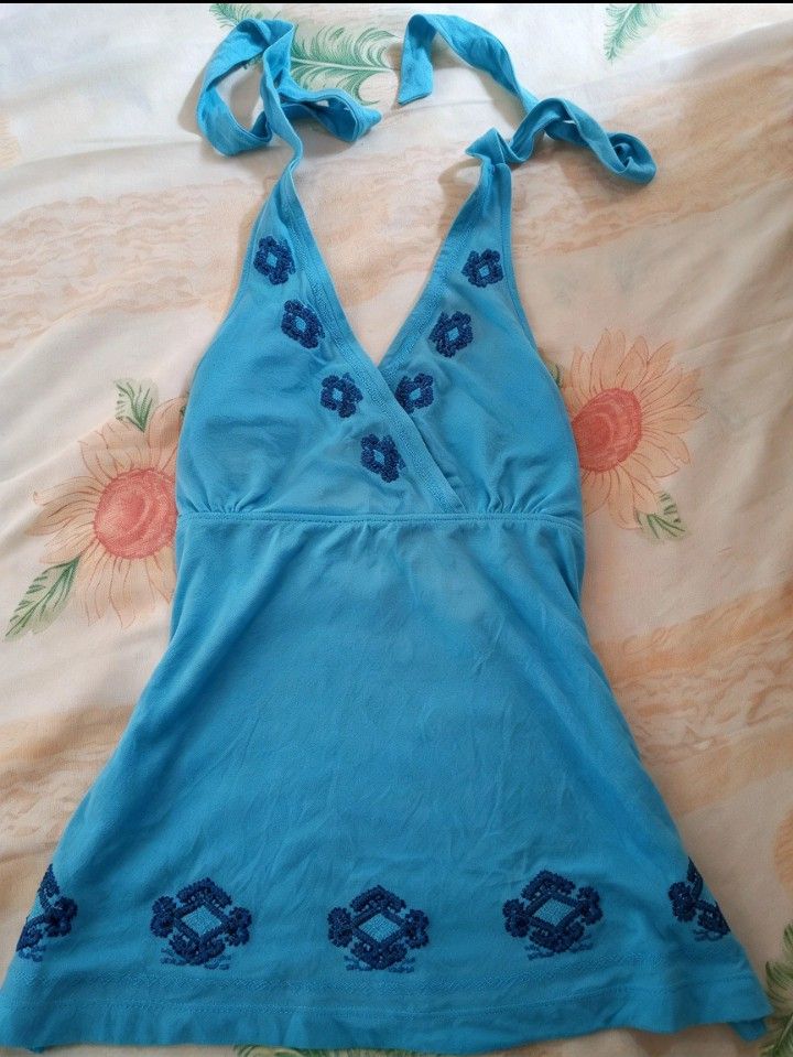 Blue Halter Neck Top with Dark Blue Embroidery (Category: Sleeveless) located in Rizal. Submitted by hawt_sawl (Listing ID 1465617549, Image 1). Description: - Color: Bright blue with dark blue floral embroidery - Material: Soft, breathable cotton - Design: Halter neck with self-tie straps, V-neckline, and sleeveless - Fit: Flowy at the waist - Style: Great casual piece for summer.