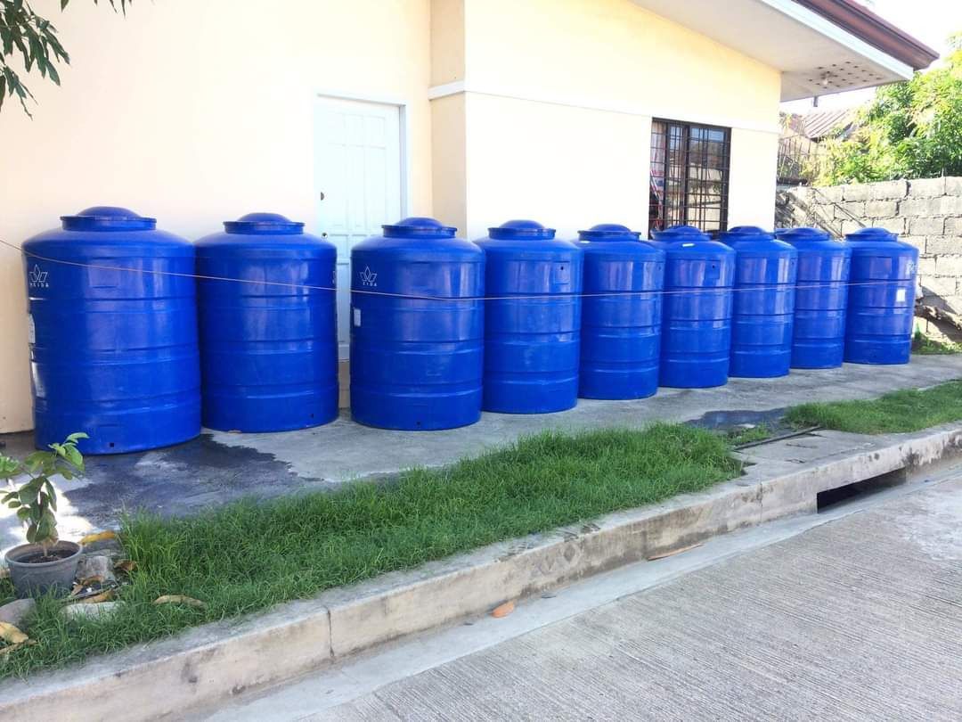 Blue Plastic Water Storage Tank Drum (Category: Hose and Watering Devices) located in Caloocan City. Submitted by vastbird_4f59c3 (Listing ID 1465708094, Image 1). Description: Large blue plastic water tanks lined up outside. Heavy duty vertical storage containers for rain harvesting or general utility use. Multiple units available in good shape. Great for farm, industrial, or residential backup water supply. .