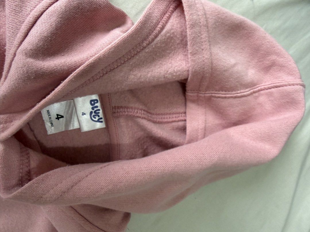 Bluey Pink Hoodie Size 4 (Category: Babies & Kids Fashion) located in Quezon City. Submitted by warmrabbit_414908 (Listing ID 1465758158, Image 3). Description: - Item: Pink Bluey & Bingo Hugging Hoodie - Size: 4 - Features: Cute front graphic with hearts, cozy fleece lining inside, long sleeves with ribbed cuffs and hem, safe drawless hood - Brand: Official Bluey branded neck tag - Condition: Minor wash wear on fabric, still very warm and wearab