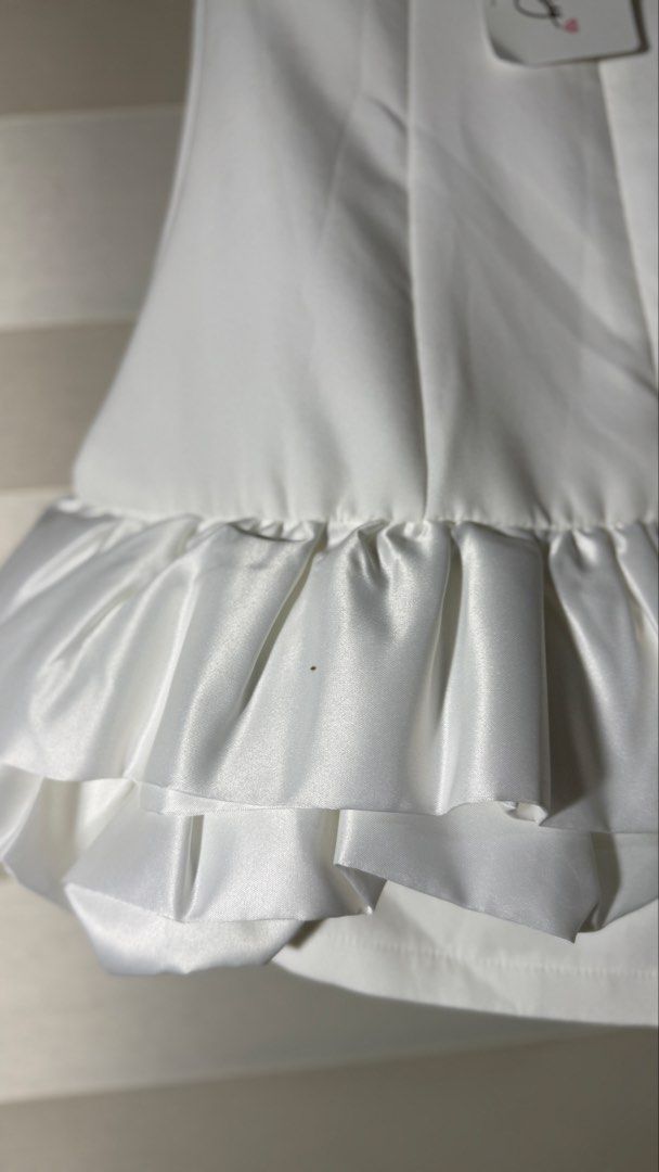 Brand New Whoopy White Ruffle Hem Romper (Category: Rompers) located in Cabanatuan. Submitted by jstne_ (Listing ID 1465634451, Image 3). Description: - Brand: Whoopy - Color: White - Style: Sleeveless romper with satin ruffle hem - Closure: Back zipper - Condition: Brand new with tag attached (small brown spot on the ruffle, see last photo).