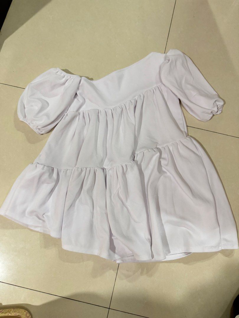 BSCO White Off-Shoulder Tiered Dress (Category: Dresses) located in Quezon City. Submitted by sweetlyluxe (Listing ID 1465624250, Image 1). Description: - Brand: BSCO - Size: Small - Color: White - Design: Off-shoulder neckline with short puff sleeves - Fabric: Textured material with flowy tiered layers - Versatile: Great to pair with jeans or skirts.