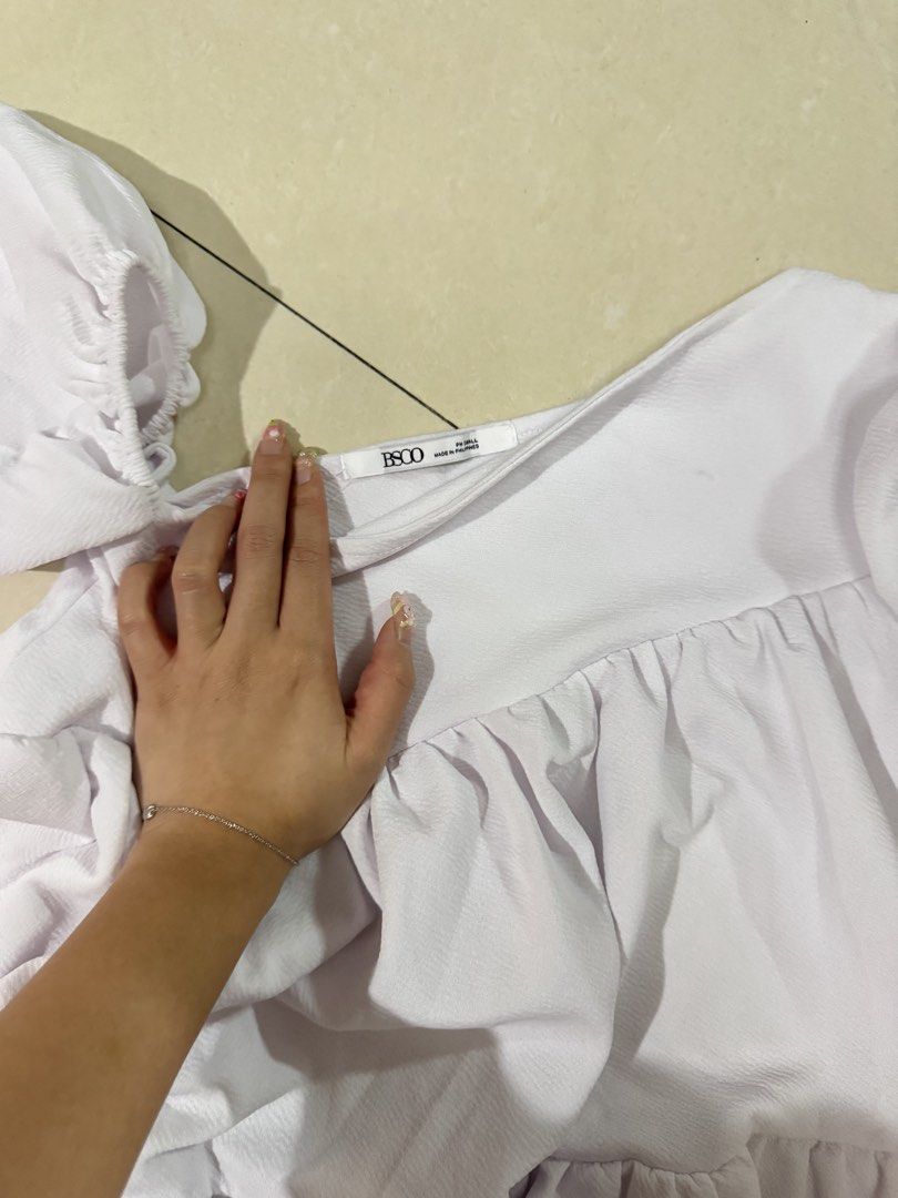 BSCO White Off-Shoulder Tiered Dress (Category: Dresses) located in Quezon City. Submitted by sweetlyluxe (Listing ID 1465624250, Image 2). Description: - Brand: BSCO - Size: Small - Color: White - Design: Off-shoulder neckline with short puff sleeves - Fabric: Textured material with flowy tiered layers - Versatile: Great to pair with jeans or skirts.