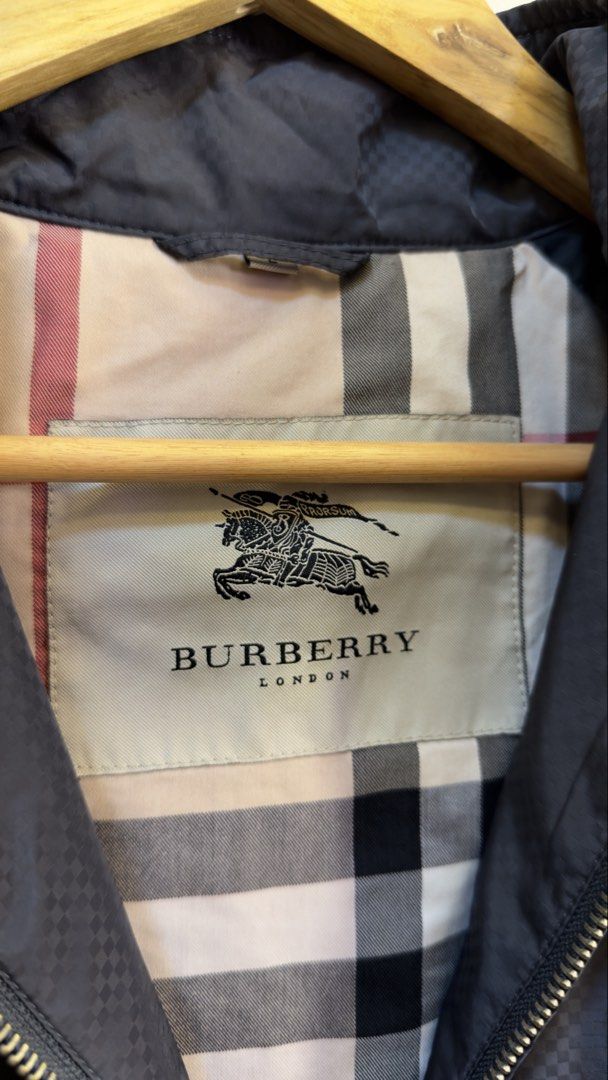 Burberry London Black Zip-Up Jacket (Category: Coats, Jackets and Outerwear) located in Paranaque City. Submitted by preluxeshop_ph (Listing ID 1465683653, Image 3). Description: Burberry London Black Zip-Up Jacket - Color: Classic Black with iconic beige, black, and red check lining - Style: Zip-up jacket with mock neck collar and subtle checkered texture - Features: Front pockets, full metal zip closure, buttoned cuffs and back yoke - Versatili