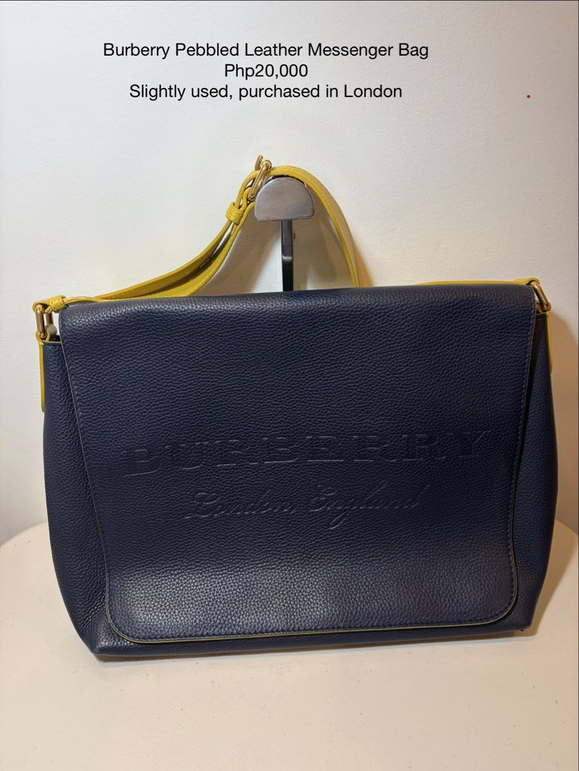 Burberry Pebbled Leather Messenger Bag (Category: Luxury Bags & Wallets) located in Bacoor. Submitted by tin.teodosio (Listing ID 1465620827, Image 1). Description: - Authentic Burberry messenger bag purchased in London - Premium navy blue pebbled leather with contrast piping - Eye-catching bright yellow strap detailing - Features debossed logo text on the front flap - Generous size to easily fit your daily essentials - Adjustable shoulder strap 