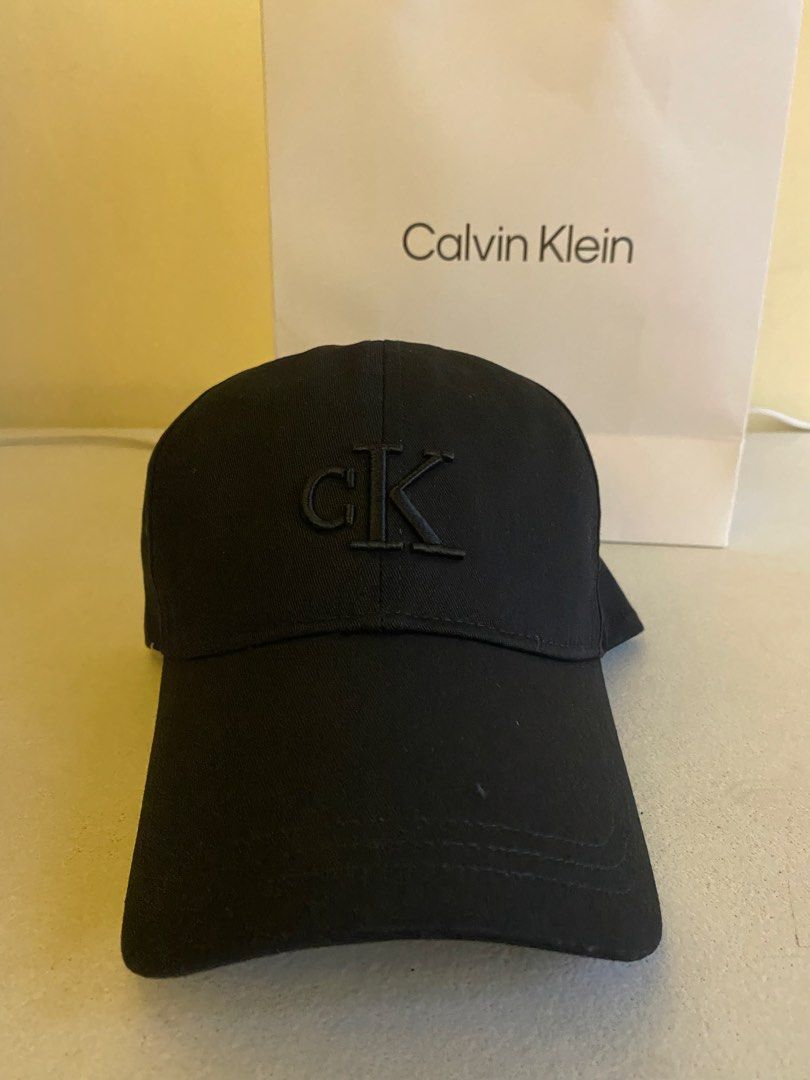 Calvin Klein Black Baseball Cap 1500 ( Decluttering ) (Category: Caps & Hats) located in Quezon City. Submitted by joelds (Listing ID 1465586670, Image 1). Description: - Authentic Calvin Klein baseball cap in classic black - Features embroidered cK logo on the front - Adjustable metal strap closure with debossed logo detail for a custom fit - Clean, versatile design that matches any casual outfit.