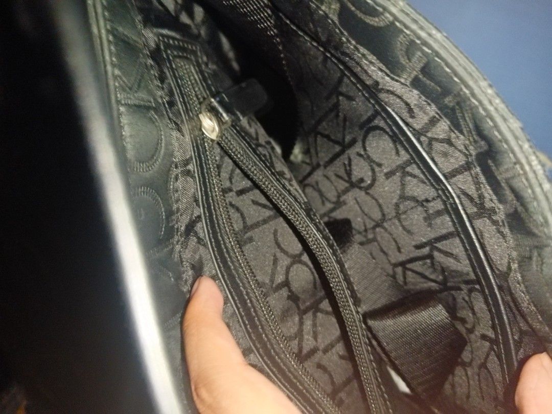 Calvin Klein Monogram Black Messenger Bag (Category: Sling Bags) located in Baguio. Submitted by valenzuela.jc (Listing ID 1465698402, Image 3). Description: Sourced from Canada - Brand: Calvin Klein - Style: Black messenger bag with iconic monogram print - Exterior: Front flap closure with metal buckle, zippered front pocket, and adjustable strap - Interior: Multiple compartments lined with matching monogram fabric - Material: Durable nylon / sy