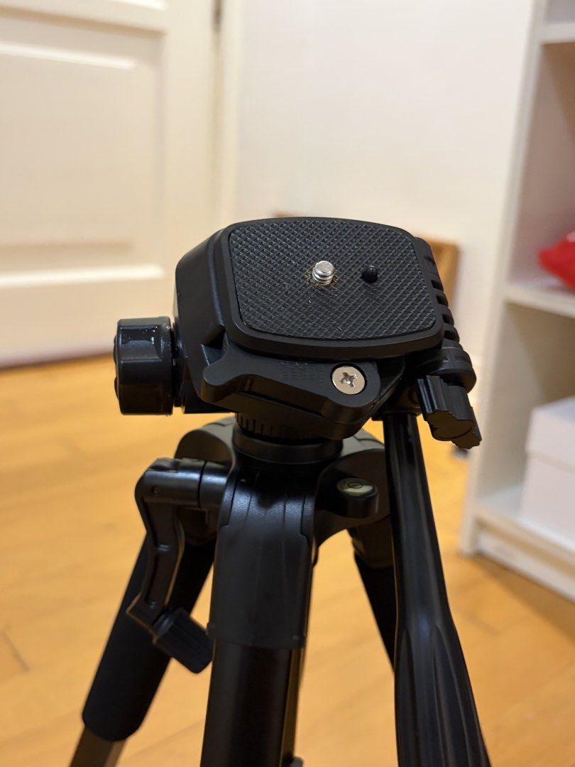 Camera Tripod With Smartphone Mount and Bag (Category: Tripods & Monopods) located in Pasig City. Submitted by sparky.shop (Listing ID 1465674154, Image 2). Description: - Sturdy black tripod suitable for both cameras and smartphones - Smooth pan head and convenient crank handle for easy height adjustment - Comfortable foam grips on legs for secure handling - Comes with a detachable phone mount featuring stylish red accents - Folds down compactly