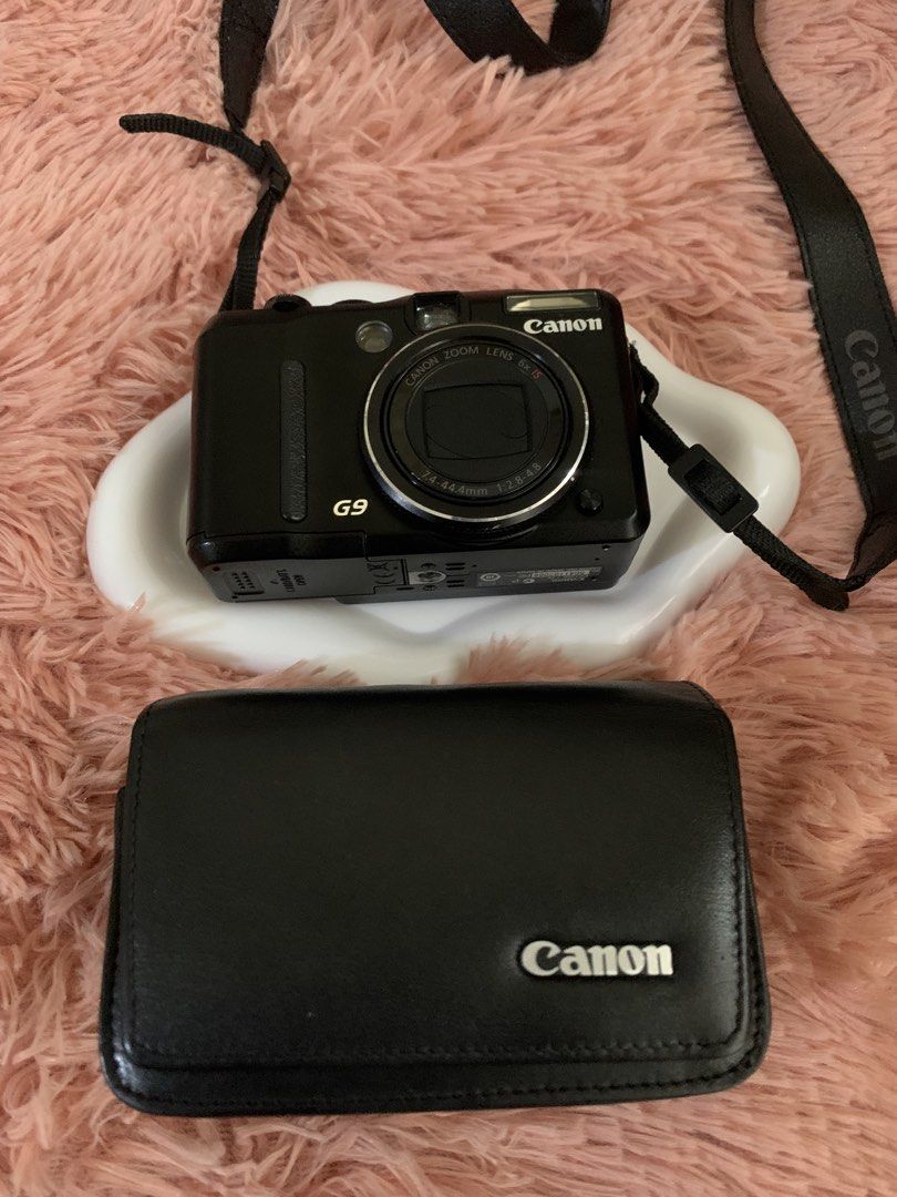 Canon PowerShot G9 Digital Camera with Case (Category: Cameras) located in Manila. Submitted by harrysuey (Listing ID 1465730977, Image 1). Description: No issue - Model: Canon PowerShot G9 digital camera (Black) - Included: Matching black Canon leather protective case and adjustable neck strap - Features: Optical zoom lens and rear LCD screen - Condition: Powers on and ready for shooting - Style: Compact vintage digital setup.