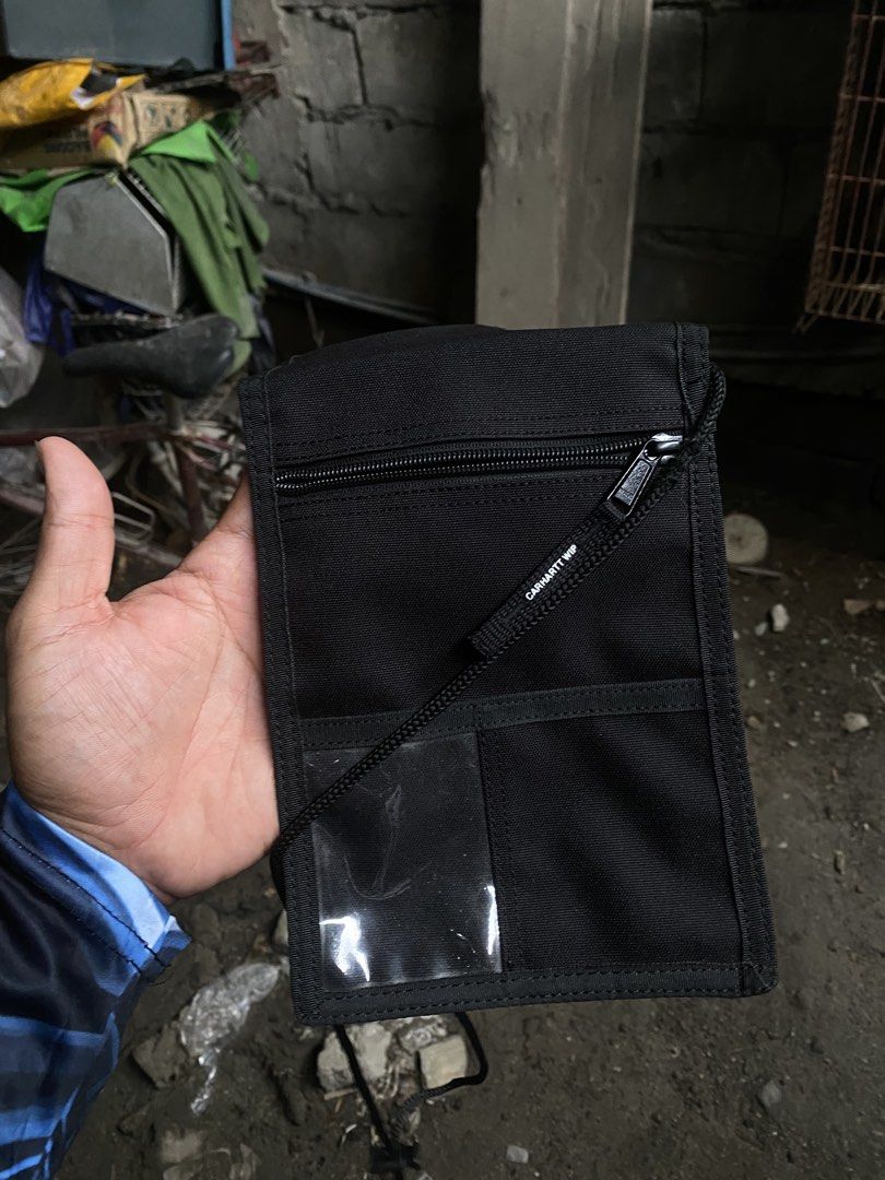 Carhartt WIP Collins Neck Pouch Black (Category: Belt bags, Clutches and Pouches) located in San Fernando. Submitted by thrifteezy6 (Listing ID 1465659871, Image 2). Description: - Brand: Carhartt WIP (Collins Neck Pouch) - Color: Classic Black - Size: One Size Fits All - Features: Handy front zip pocket, clear ID window, and main compartment with secure flap closure - Details: Adjustable black cord lanyard with toggle - Material: Durable, high-q