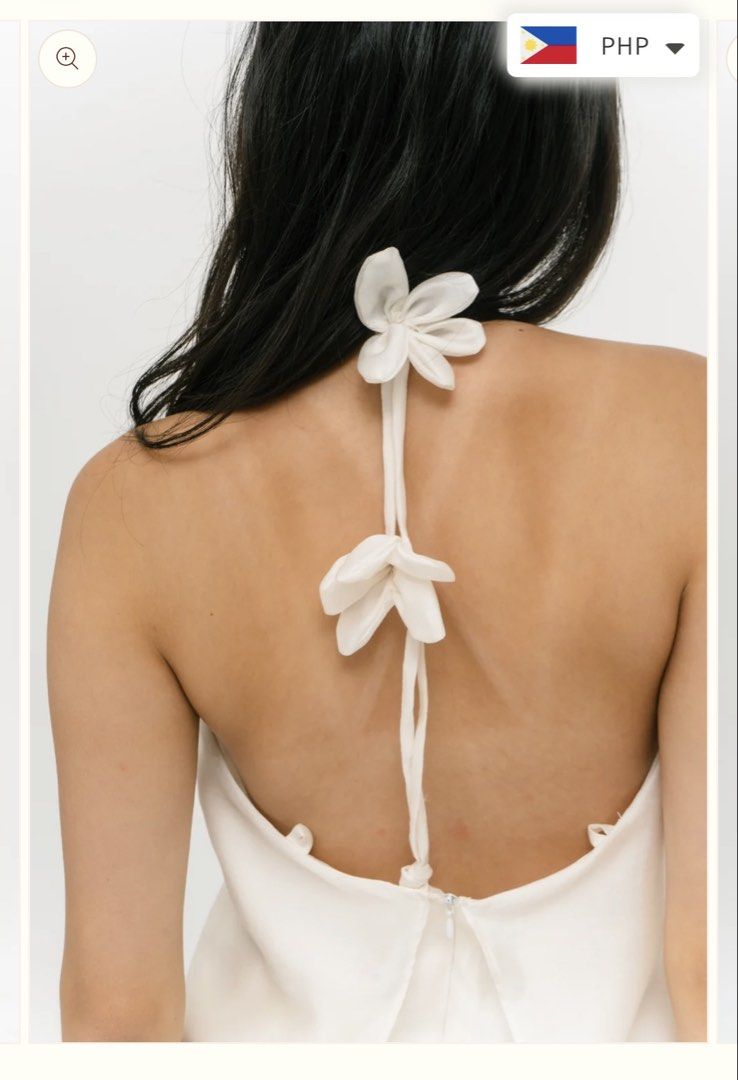 Cariño Iris Top (Category: Sleeveless) located in Manila. Submitted by nicolesdumpsite (Listing ID 1465584979, Image 2). Description: - Color: White - Style: Halter neckline mini dress with overlay top layer and matching skirt - Details: Thin back ties with attached white fabric flowers, lower back zipper closure - Fabric: Smooth, silky, and clean look - Length: Above the knee - Occasion: Perfect for dinners, dates, and night outs USED ONLY ONCE 