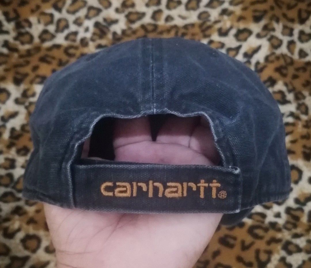 Carousell Carhartt Black Cap with Leather Patch (Category: Caps & Hats) located in Cebu City. Submitted by roadthrift (Listing ID 1465702282, Image 2). Description: - Brand: Carhartt - Color: Black washed - Design: Square brown leather logo patch on front - Back: Adjustable velcro closure with embroidered Carhartt lettering - Fit: Unstructured casual fit with ventilation eyelets - Details: Inner band features 'Built to Serve and Protect, Hardwork