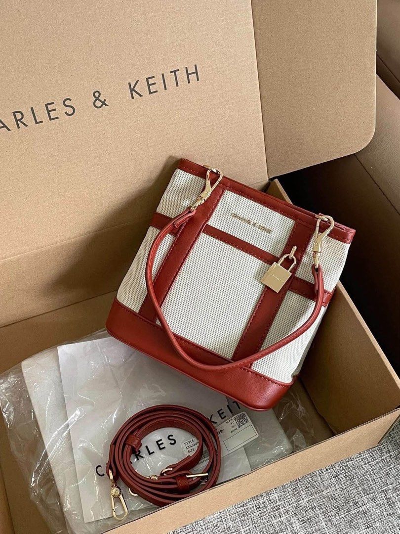 Charles & Keith Canvas Bucket Bag with Strap (Category: Cross-body Bags) located in Pasig City. Submitted by bagsnmore4 (Listing ID 1465581079, Image 1). Description: - Brand: Charles & Keith - Material: Canvas and brown faux leather - Hardware: Gold-tone with front pocket padlock charm - Straps: Dual top handles and adjustable Condition : Brand new .