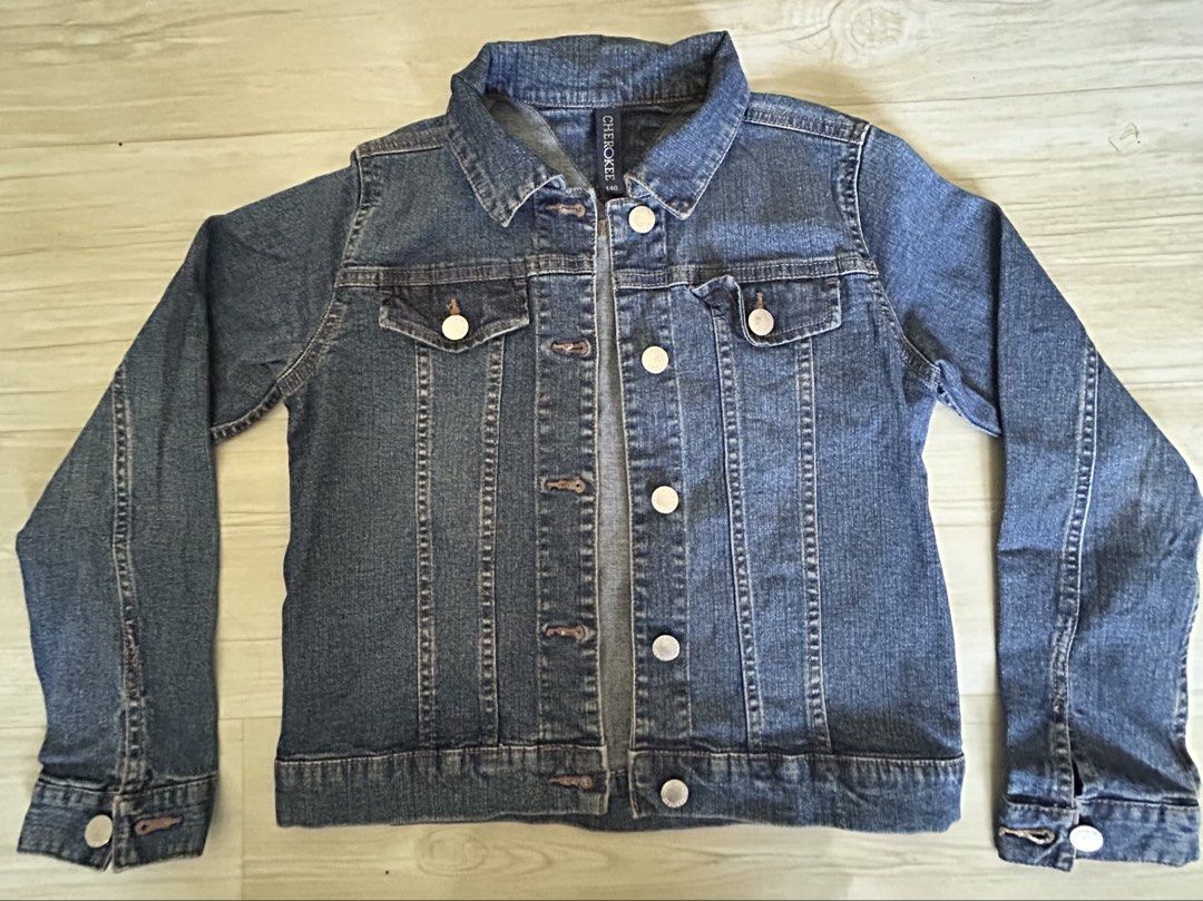 Cherokee Denim Jacket Size 140 (Category: Babies & Kids Fashion) located in Manila. Submitted by ai010 (Listing ID 1465630043, Image 1). Description: - Brand/Model: Cherokee Denim Jacket - Size: 140 - Color: Classic Blue Denim - Closure: Button-up front with metal buttons and button cuffs - Pockets: Dual chest flap pockets with button closures - Details: Structured collar and traditional contrast stitching throughout.