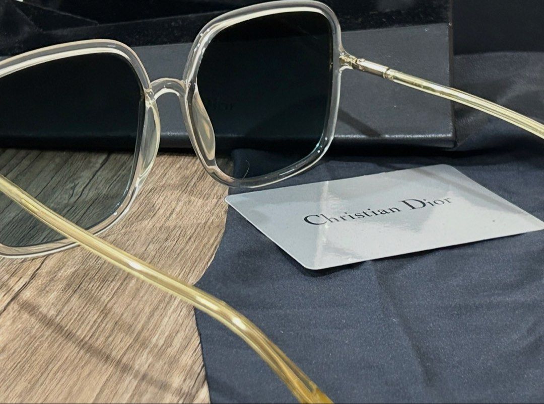 Christian Dior Square Sunglasses with Case (Category: Sunglasses & Eyewear) located in Manila. Submitted by eeerk (Listing ID 1465673472, Image 1). Description: - Brand: Christian Dior - Style: Oversized square sunglasses - Frame: Clear translucent with gold-tone temples and subtle CD logo - Lenses: Dark gradient - Inclusions: Branded hard case, black pouch, and information card - Condition: Great statement accessory for sunny days.