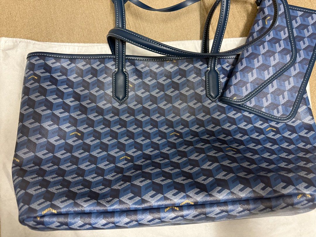 Christy Ng Blue Pattern Tote Bag with Pouch (Category: Tote Bags) located in Pasig City. Submitted by cvj25 (Listing ID 1465685920, Image 2). Description: - Brand: Christy Ng - Design: Chic blue geometric pattern - Straps: Sturdy dark blue leather handles - Includes: Matching flap pouch and branded white dust bag - Features: Roomy interior for daily essentials - Condition: Pristine, ready for everyday use.