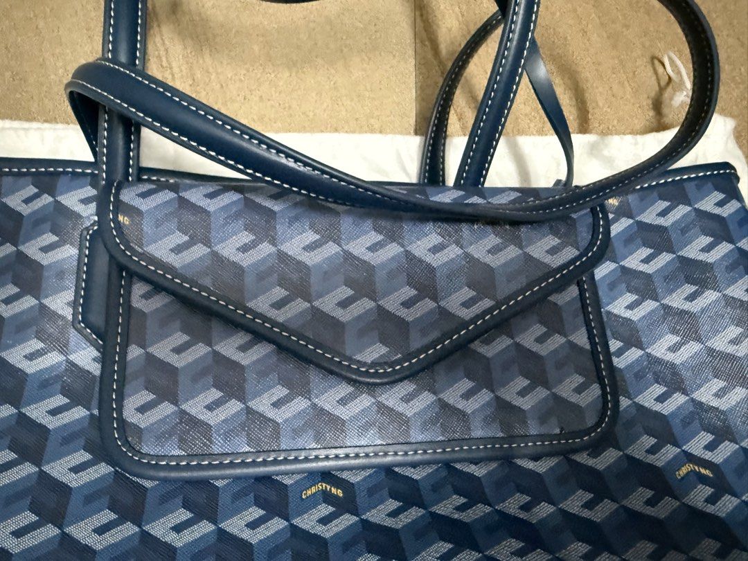 Christy Ng Blue Pattern Tote Bag with Pouch (Category: Tote Bags) located in Pasig City. Submitted by cvj25 (Listing ID 1465685920, Image 3). Description: - Brand: Christy Ng - Design: Chic blue geometric pattern - Straps: Sturdy dark blue leather handles - Includes: Matching flap pouch and branded white dust bag - Features: Roomy interior for daily essentials - Condition: Pristine, ready for everyday use.