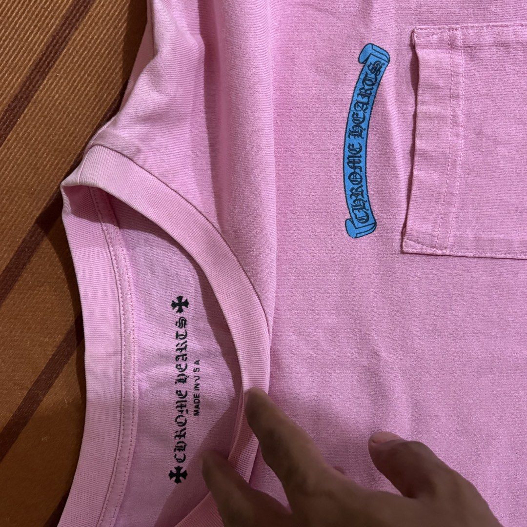 Chrome Hearts Pink Scroll Pocket T-Shirt (Category: Tshirts & Polo Shirts ) located in Manila. Submitted by carlmachu (Listing ID 1465704097, Image 2). Description: - Brand: Chrome Hearts - Color: Bright pink - Design: Blue scroll logo print on chest pocket and sleeve - Fit: Classic crew neck, short sleeve - Origin: Made in USA - Condition: Clean fabric overall with original collar branding.