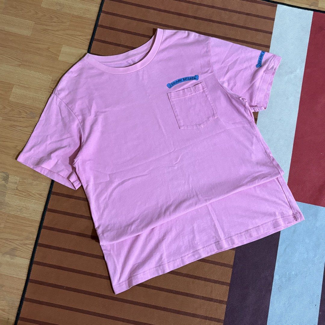 Chrome Hearts Pink Scroll Pocket T-Shirt (Category: Tshirts & Polo Shirts ) located in Manila. Submitted by carlmachu (Listing ID 1465704097, Image 1). Description: - Brand: Chrome Hearts - Color: Bright pink - Design: Blue scroll logo print on chest pocket and sleeve - Fit: Classic crew neck, short sleeve - Origin: Made in USA - Condition: Clean fabric overall with original collar branding.