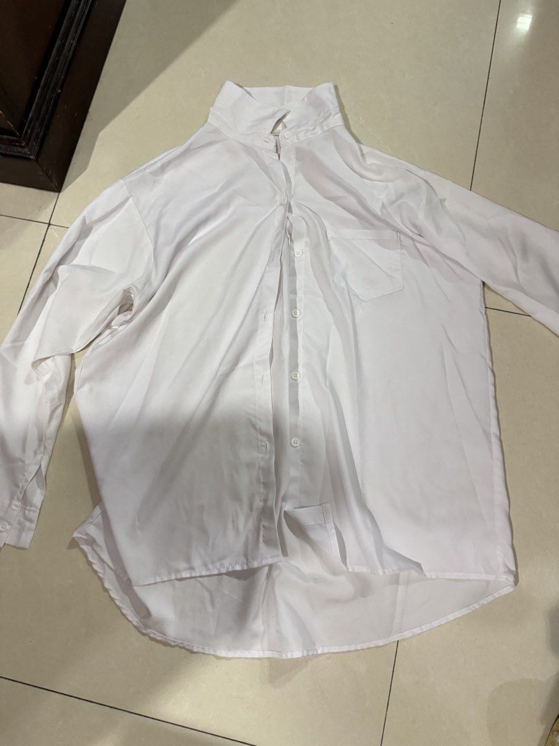 Classic White Button-Up Long Sleeve Shirt (Category: Longsleeves) located in Quezon City. Submitted by sweetlyluxe (Listing ID 1465624531, Image 1). Description: - Color: Plain white - Style: Long sleeves, classic collar, chest pocket, curved hem (longer in back) - Material: Soft, lightweight fabric - Versatility: Perfect for office wear or casual layering.