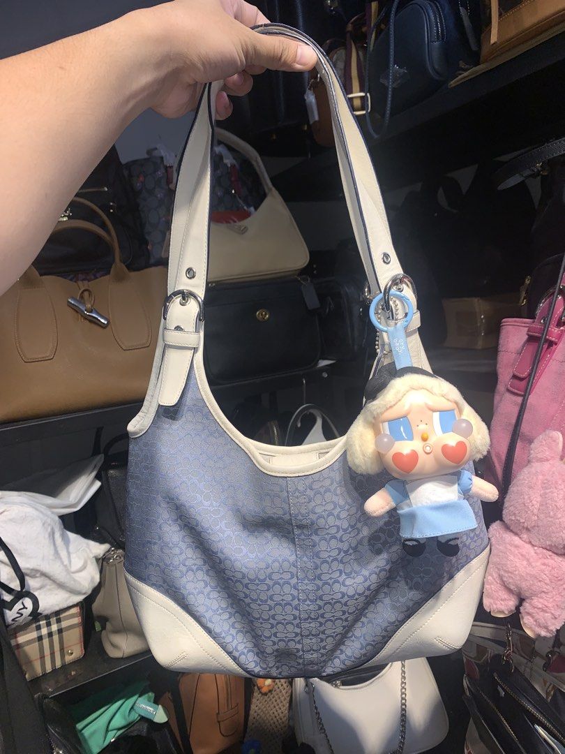 Coach blue monogram shoulder bag with charm (Category: Shoulder Bags) located in Mataasnakahoy. Submitted by grailsph.81630 (Listing ID 1465747184, Image 1). Description: - Authentic blue monogram Coach shoulder bag - Features white leather trim and straps with stylish side buckle details - Comes with a trendy hanging Crybaby character plush keychain - Impeccably clean interior and exterior.