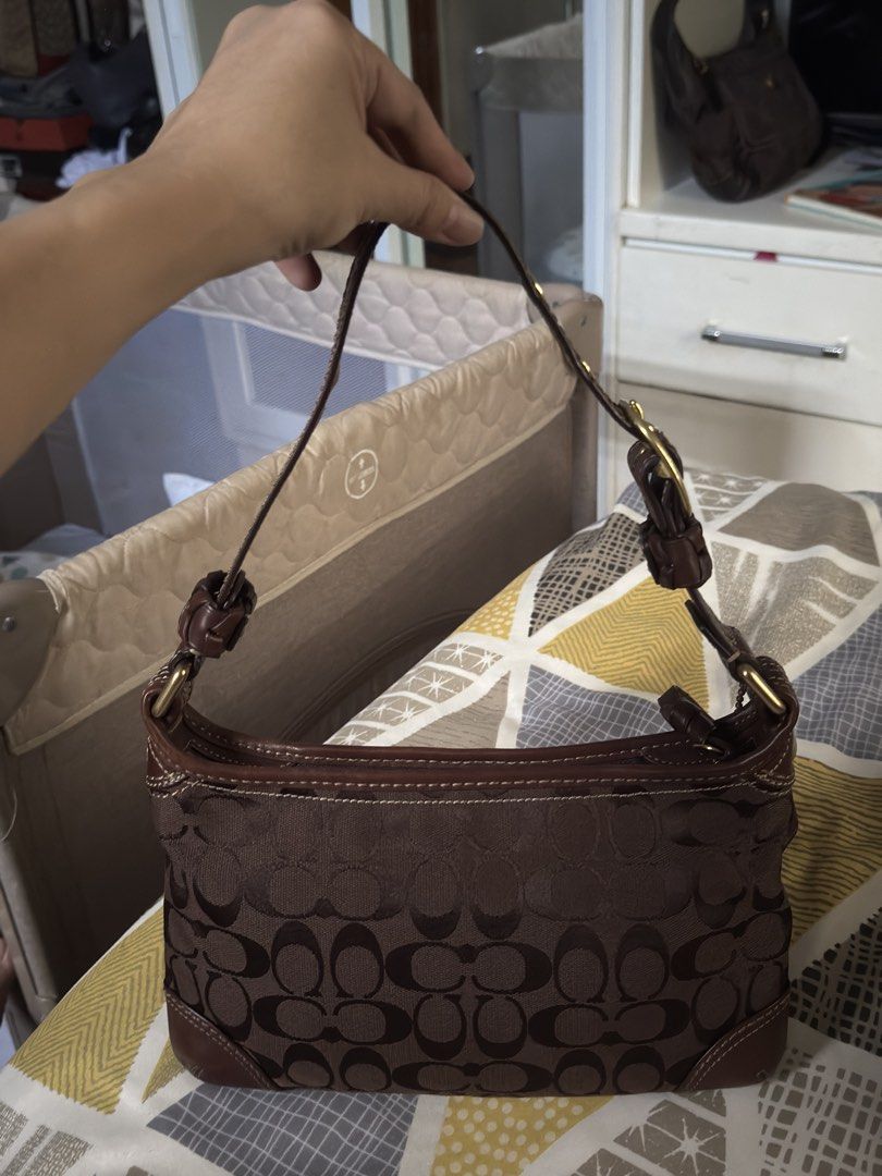 Coach Brown Signature Monogram Shoulder Bag (Category: Luxury Bags & Wallets) located in Makati City. Submitted by cars_online (Listing ID 1465641337, Image 1). Description: - Authentic brown Coach shoulder bag with classic signature monogram pattern - Premium dark brown leather trim on the bottom corners and top edge - Secure top zipper closure to keep your essentials safe - Adjustable strap featuring buckle hardware and trendy knotted side deta