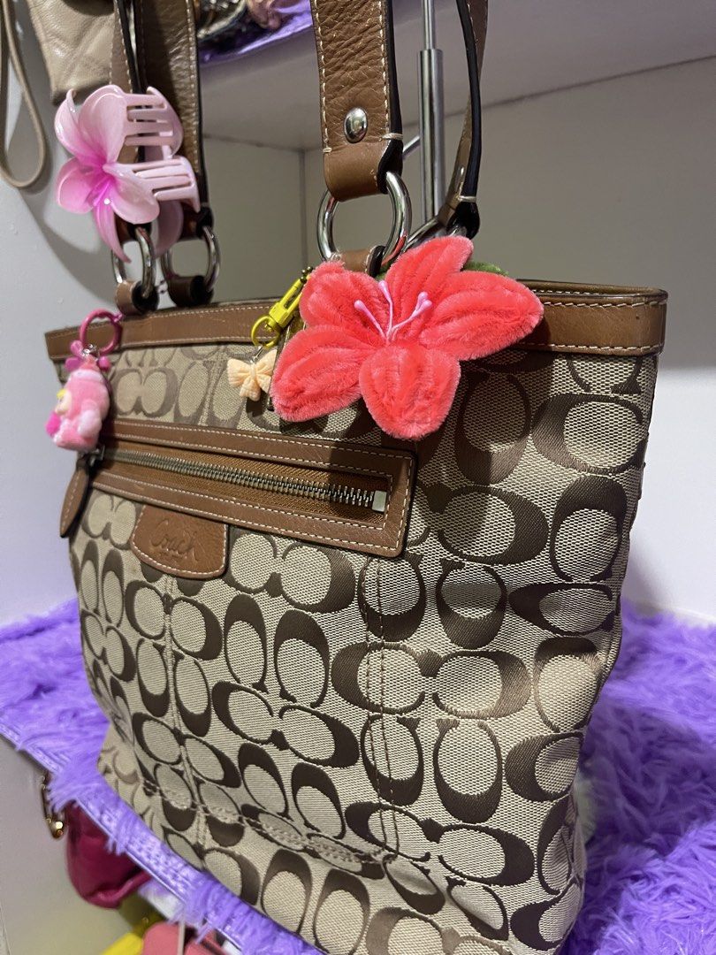 Coach Penelope shopper tote bag (Category: Luxury Bags & Wallets) located in Manila. Submitted by just_loved (Listing ID 1465745340, Image 3). Description: - Authentic Coach signature C canvas body in beige and brown - Premium brown leather trim, dual straps, and gold hardware - Front exterior zip pocket with Coach leather patch and iconic hangtag - Pre-accessorized with cute charms and hair clips attached to rings and zipper - Spacious everyday 