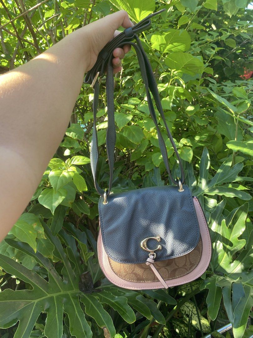 Coach Colorblock Saddle Bag (Category: Luxury Bags & Wallets) located in Manila. Submitted by cdb_22 (Listing ID 1465596552, Image 2). Description: - Authentic Coach crossbody saddle bag - Stylish mix of signature monogram canvas, dark grey pebbled leather, and pale pink trim - Elegant gold hardware with iconic C clasp and cute leather tie closure - Features an adjustable shoulder strap for customized comfort - Includes a matching pink Coach hang