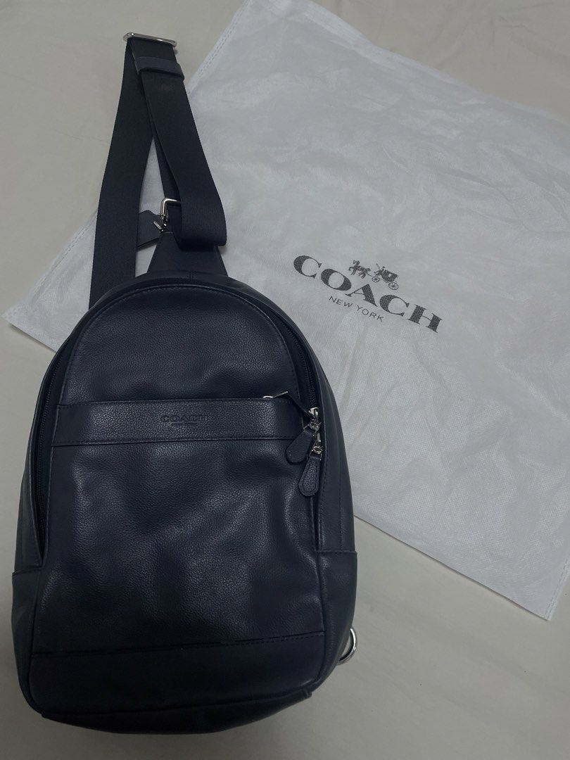 Coach New York Leather Sling Backpack (Category: Luxury Bags & Wallets) located in Angeles City. Submitted by lukemafinds (Listing ID 1465674357, Image 1). Description: - Authentic Coach New York leather sling backpack - Color: Dark navy blue - Versatile single adjustable strap for cross-body or shoulder wear - Front zip compartment with debossed Coach logo - Secure double-zipper main compartment - Clean fabric-lined interior with snap closure po