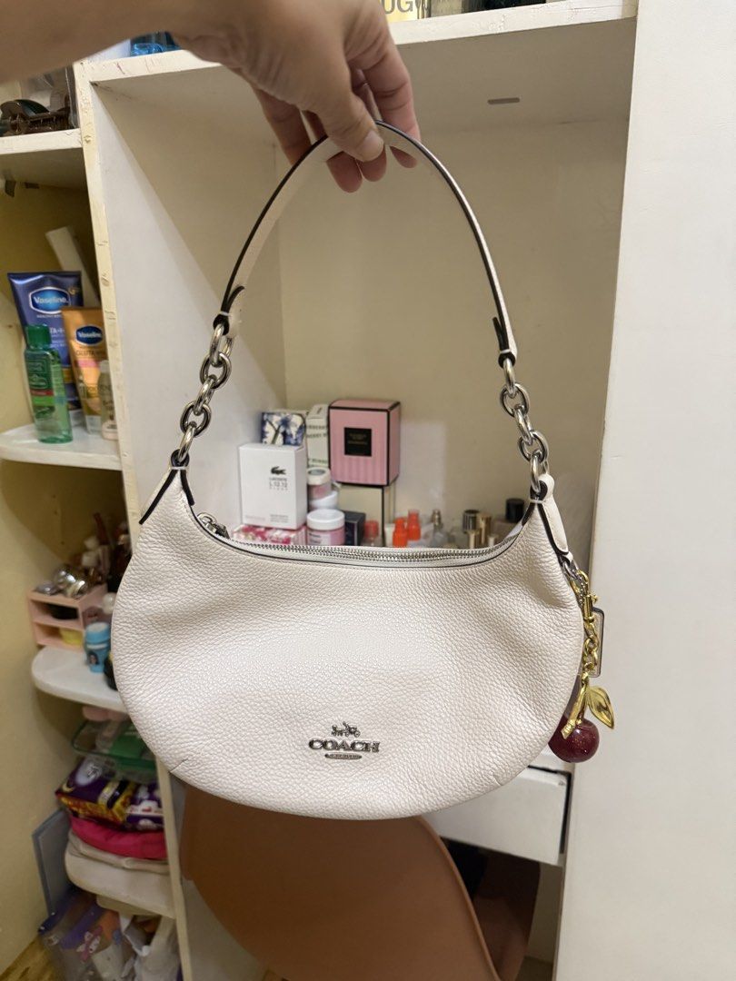 Coach Python Large Size (Category: Luxury Bags & Wallets) located in Bato. Submitted by babylaarni26255 (Listing ID 1465758651, Image 2). Description: - Authentic Coach shoulder bag in white pebbled leather - Silver-tone hardware and secure zipper closure - Stylish chain link accents on the strap - Includes a blank hangtag and adorable cherry bag charm with a gold stem and leaf - Compact and lightweight, ideal for daily essentials - Excellent, cl