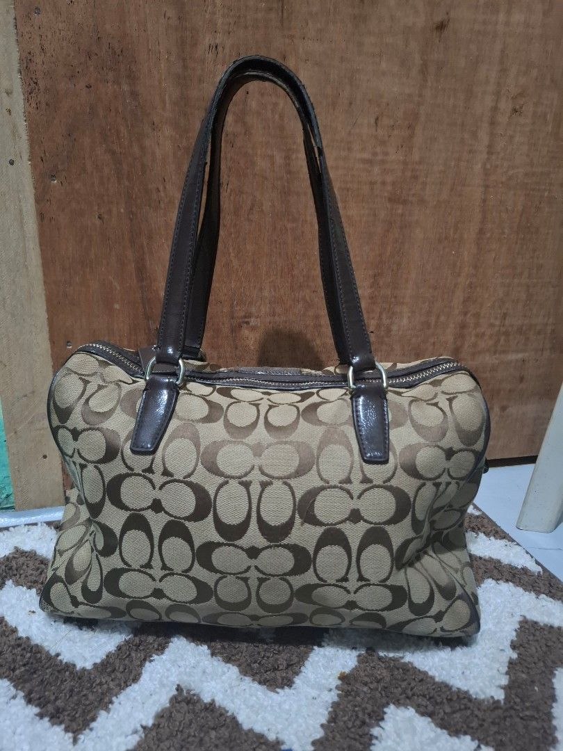 Coach Signature C Brown Canvas Shoulder Bag (Category: Luxury Bags & Wallets) located in Pasig City. Submitted by pingsrarefinds (Listing ID 1465720218, Image 2). Description: - Authentic Coach shoulder bag in classic brown signature C canvas - Dark brown leather handles, trim, and matching hangtag - Secure top zipper closure to keep your belongings safe - Roomy main compartment with great everyday utility - Solid hardware detailing throughout.