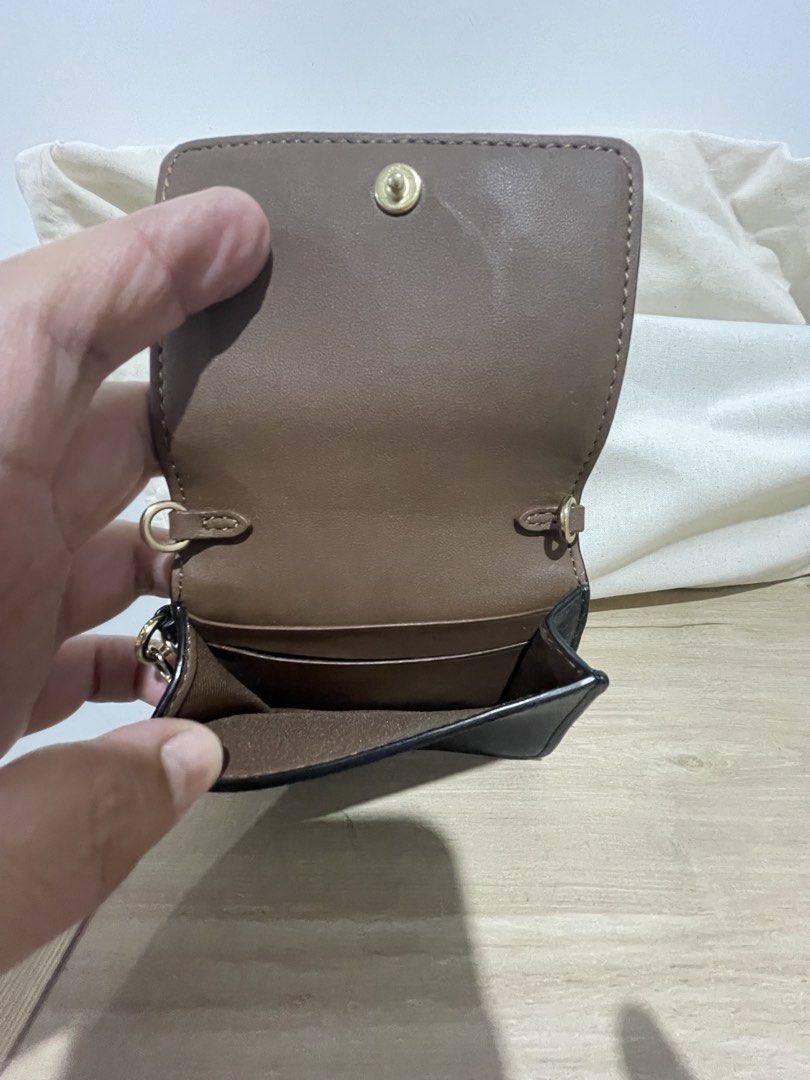 Coach Signature Canvas Mini Wallet with Charm (Category: Wallets & Card holders) located in Cordova. Submitted by fiercedragon.47e450 (Listing ID 1465710312, Image 3). Description: - Authentic Coach wallet in classic signature brown canvas - Elegant gold-tone hardware with a secure snap closure - Interior includes a card slot and a convenient cash compartment - Comes with an adorable attached bear and key pendant charm - Compact size, ideal for s