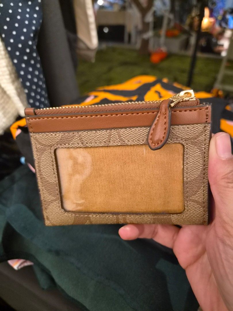 Coach Signature Canvas Mini Zip Case Brown (Category: Luxury Bags & Wallets) located in Paranaque City. Submitted by regf_01 (Listing ID 1465669719, Image 1). Description: - Authentic Coach Card Case - Color: Brown Signature Canvas with Tan Leather Trim - Hardware: Gold-tone - Closure: Zip-top with leather pull - Features: ID window on one side, multiple card slots on the other - Size: Compact, fits easily in pockets and small bags - Condition: L