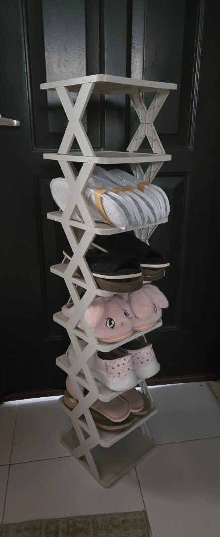 Collapsible White Plastic Shoe Rack Organizer (Category: Storage Boxes & Baskets) located in Dasmarinas. Submitted by .queen____ (Listing ID 1465645531, Image 2). Description: - Color: White - Material: Durable and lightweight plastic - Design: Foldable with a stable cross-brace structure - Features: Space-saving and multi-tier capacity for multiple pairs of shoes - Placement: Perfect for doorways, entryways, or inside closets - Condition: Clean 