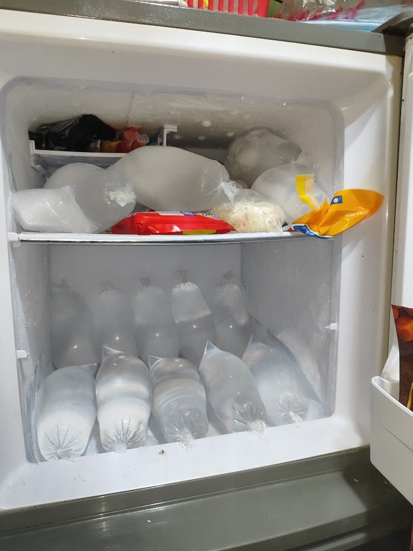 Condura Two Door Refrigerator (Category: Refrigerators and Freezers) located in Cavite. Submitted by itsmeki (Listing ID 1465673318, Image 2). Description: - Brand/Model: Two-door Condura refrigerator - Color: Sleek dark grey - Freezer: Top compartment - Refrigerator: Equipped with wire shelving, bottle racks, and a bottom crisper drawer - Condition: Clean interior with ample storage space for groceries and drinks - Note: Exterior includes decora