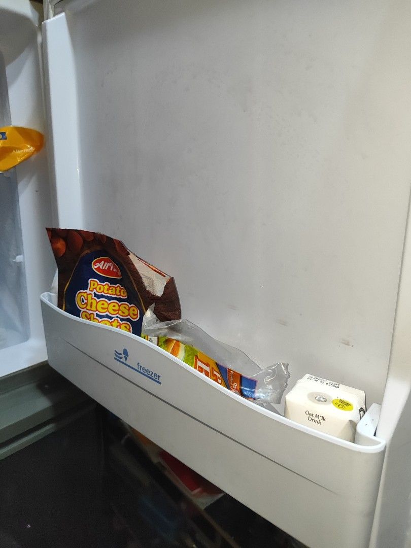 Condura Two Door Refrigerator (Category: Refrigerators and Freezers) located in Cavite. Submitted by itsmeki (Listing ID 1465673318, Image 3). Description: - Brand/Model: Two-door Condura refrigerator - Color: Sleek dark grey - Freezer: Top compartment - Refrigerator: Equipped with wire shelving, bottle racks, and a bottom crisper drawer - Condition: Clean interior with ample storage space for groceries and drinks - Note: Exterior includes decora