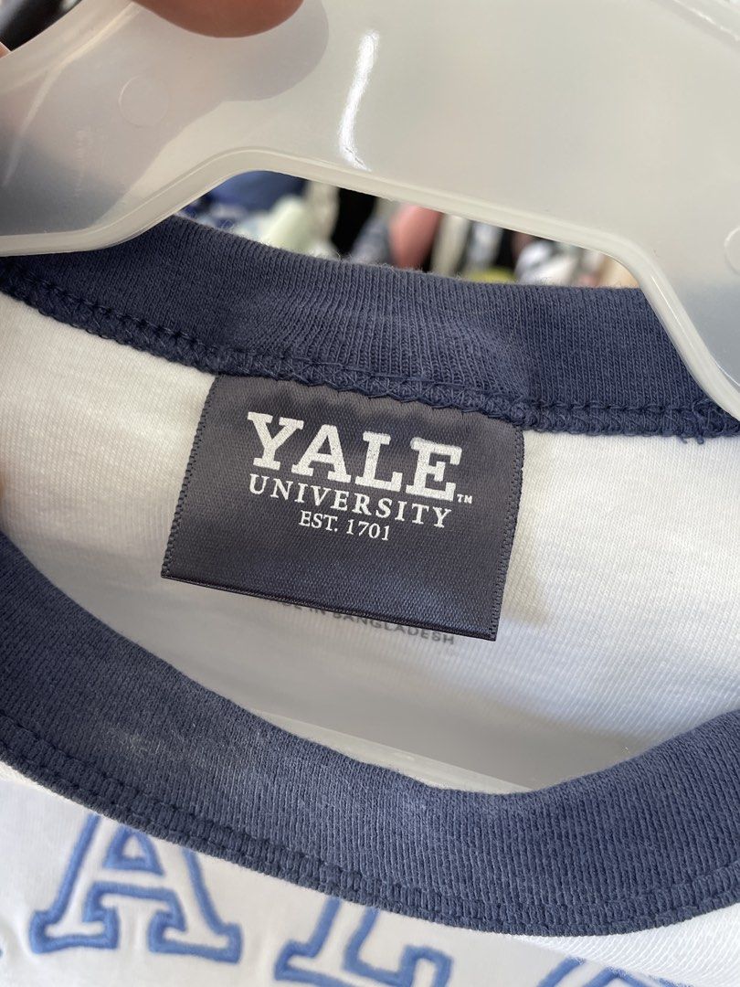 Cotton On Yale University Micro Tee Size M (Category: Shirts) located in Lucena. Submitted by riyizthriftz (Listing ID 1465704184, Image 3). Description: - Brand: Cotton On - Design: Yale University micro tee in white with navy blue raglan sleeves and collar - Detailing: Embroidered Yale crest and lettering across the chest - Fit: Cropped, short sleeve style - Size: M - Material: Soft cotton blend - Condition: Clean, no stains or damage noted.