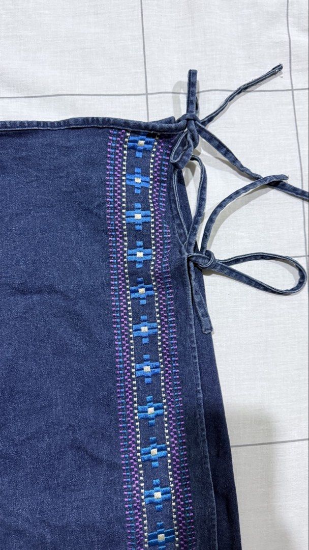 Dark denim wrap skirt with embroidered border (Category: Skirts) located in Taytay. Submitted by chichays (Listing ID 1465581740, Image 2). Description: - Dark denim wrap skirt with a flattering midi length - Adjustable side tie closure for a customized, comfortable waist fit - Eye-catching blue, white, and purple geometric embroidery along the front edge - perfect for xxs-xs girly.