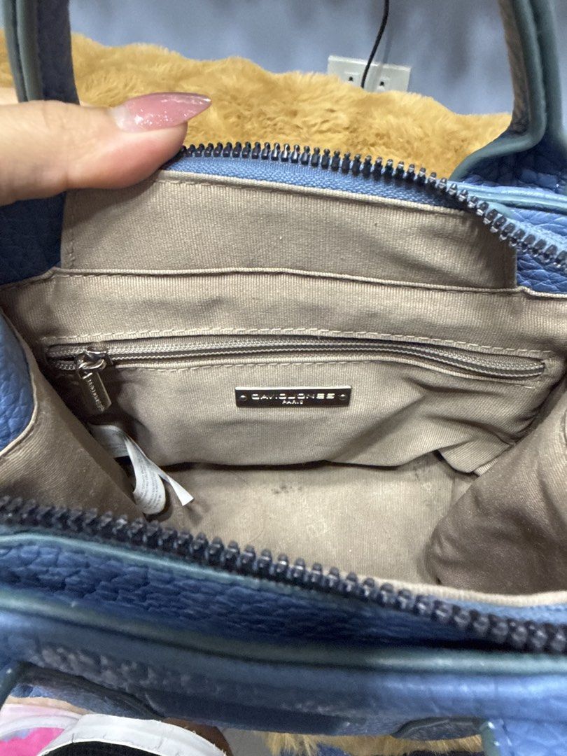 David Jones Blue Tote Handbag (Category: Tote Bags) located in Alaminos. Submitted by jhean1323 (Listing ID 1465584323, Image 3). Description: - Brand: David Jones - Color/Material: Blue pebble textured faux leather - Versatile carry: Dual top handles and a detachable crossbody strap - Secure closure: Zip top - Interior features: Beige fabric lining, one zipper pocket, and metal brand logo plate - Size: Compact, ideal for everyday use - Condition