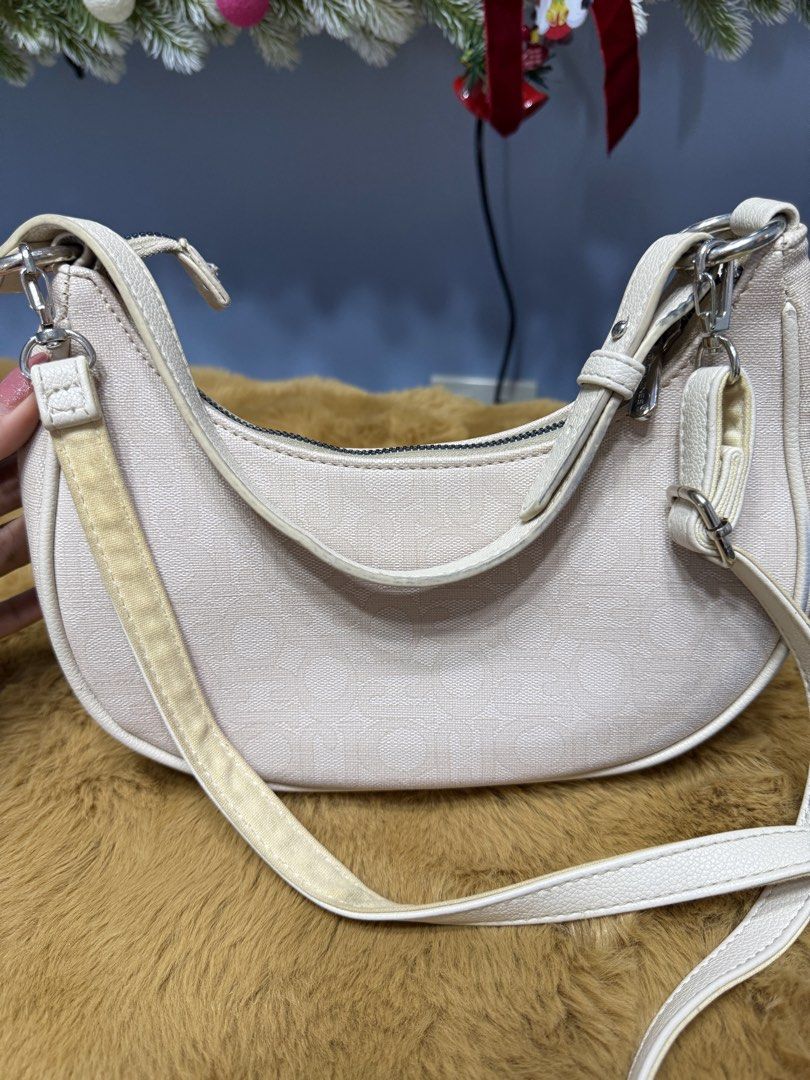David Jones Cream Crescent Shoulder Bag (Category: Shoulder Bags) located in Alaminos. Submitted by jhean1323 (Listing ID 1465584511, Image 2). Description: - Brand/Model: David Jones crescent shoulder bag - Color/Material: Cream textured fabric with silver-tone hardware and metal front logo - Closure & Interior: Secure zip top closure with a lined interior and a convenient zipped pocket - Strap: Includes an adjustable and removable strap (Flaw n
