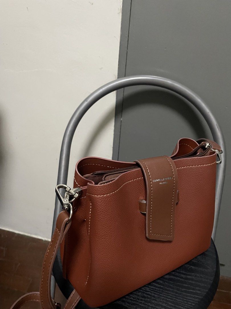David Jones Paris Brown Shoulder Bag (Category: Shoulder Bags) located in Cebu City. Submitted by swiftwater_ff15e4 (Listing ID 1465753444, Image 2). Description: - Brand: David Jones Paris - Color: Rich brown with contrast white stitching - Design: Structured pebble-texture with center strap flap and silver-tone metallic branding - Closure: Secure zippered top closure - Strap: Detachable matching shoulder strap with silver clasps - Condition: Ex