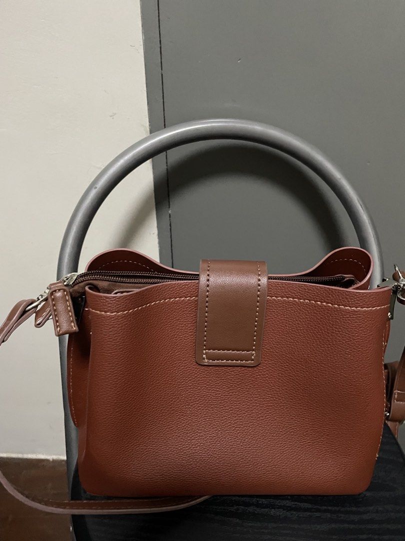 David Jones Paris Brown Shoulder Bag (Category: Shoulder Bags) located in Cebu City. Submitted by swiftwater_ff15e4 (Listing ID 1465753444, Image 3). Description: - Brand: David Jones Paris - Color: Rich brown with contrast white stitching - Design: Structured pebble-texture with center strap flap and silver-tone metallic branding - Closure: Secure zippered top closure - Strap: Detachable matching shoulder strap with silver clasps - Condition: Ex